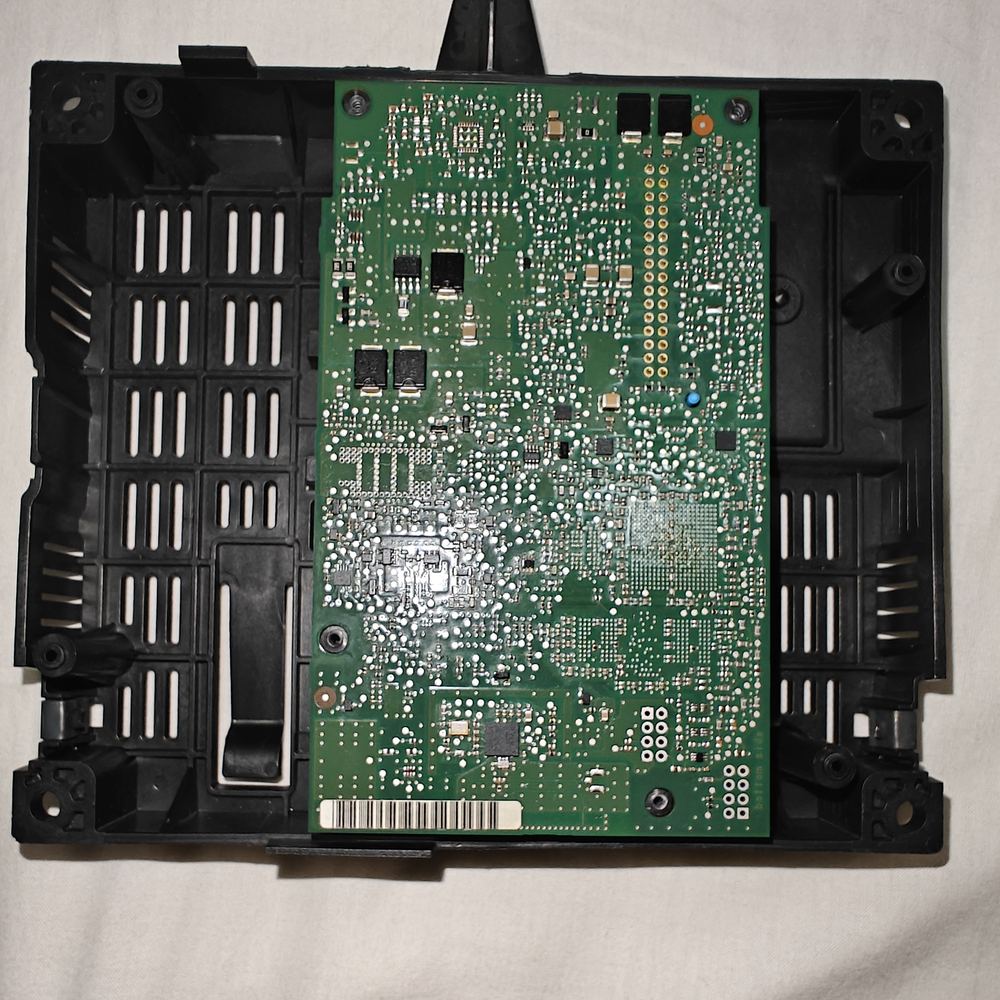 The opened case with the original green circuit board lying in it.