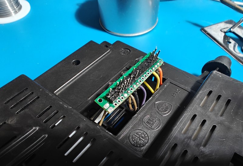 Small perfboard with connector pins and wires passing into the case.